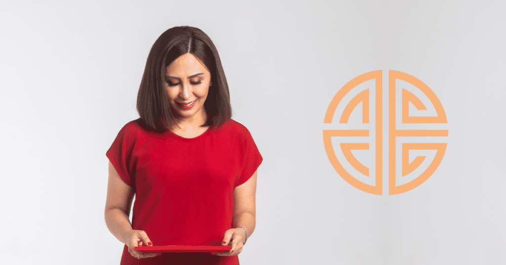 Person in a red shirt looking down at a red tablet, next to a circular geometric logo on a white background.